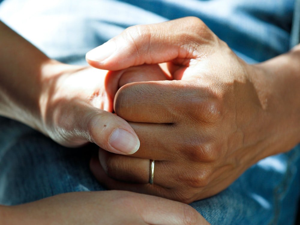 Two people holding hands in a gesture of care