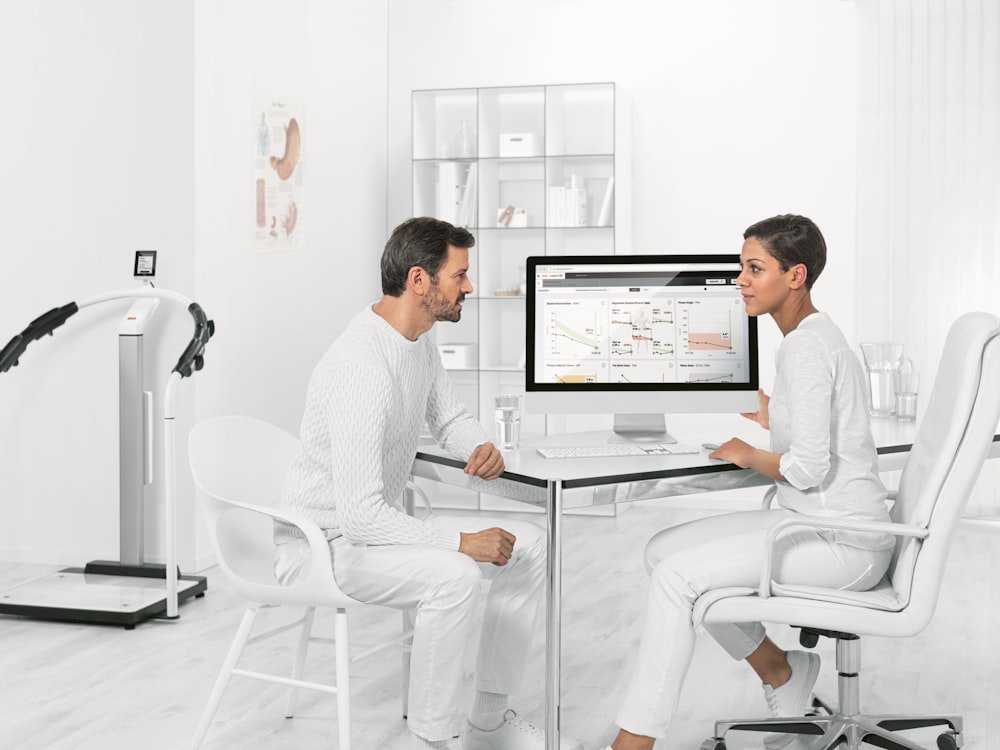 Two people meeting across a desk in a bright office